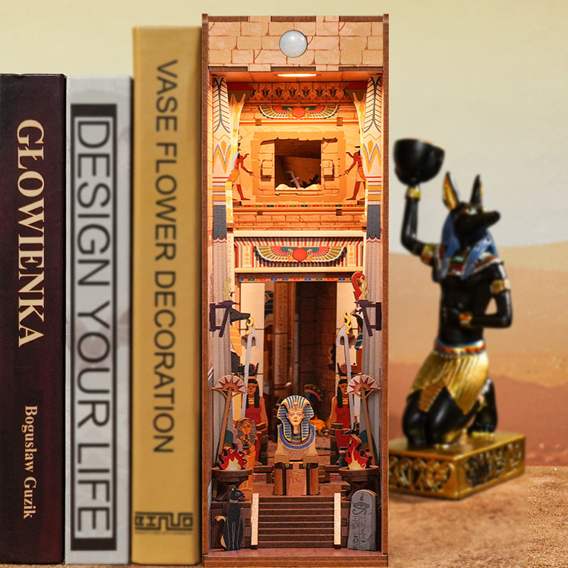 The assembled "Adventure in Egypt" book nook placed on a shelf between books, demonstrating its use as a unique, illuminated bookshelf insert.