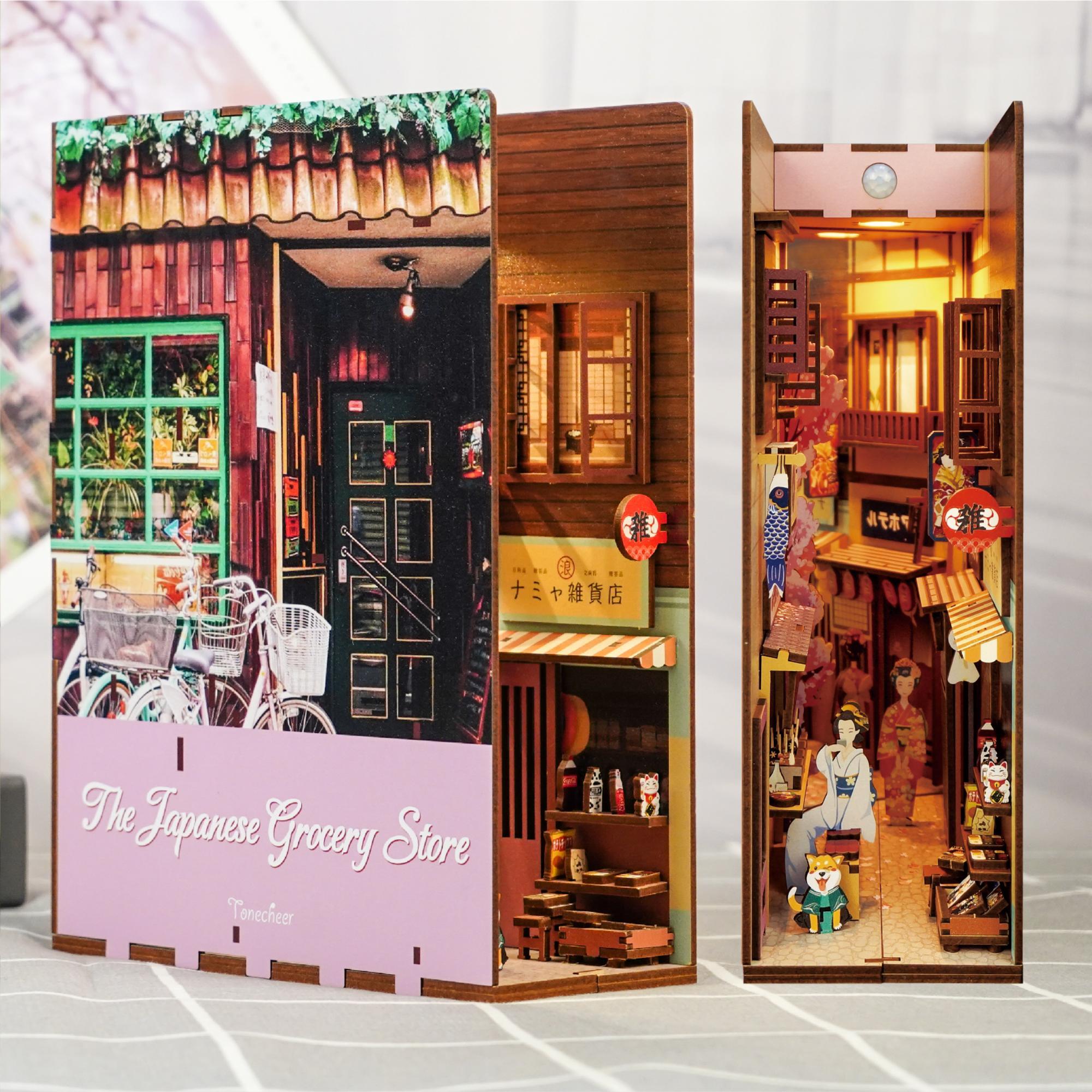 The assembled "The Japanese Grocery Store" book nook displayed next to its front cover, showing the deep interior alley and storefront facade.