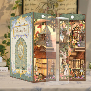 The assembled book nook kit displayed with the included transparent dust cover piece being placed over the detailed interior scene.