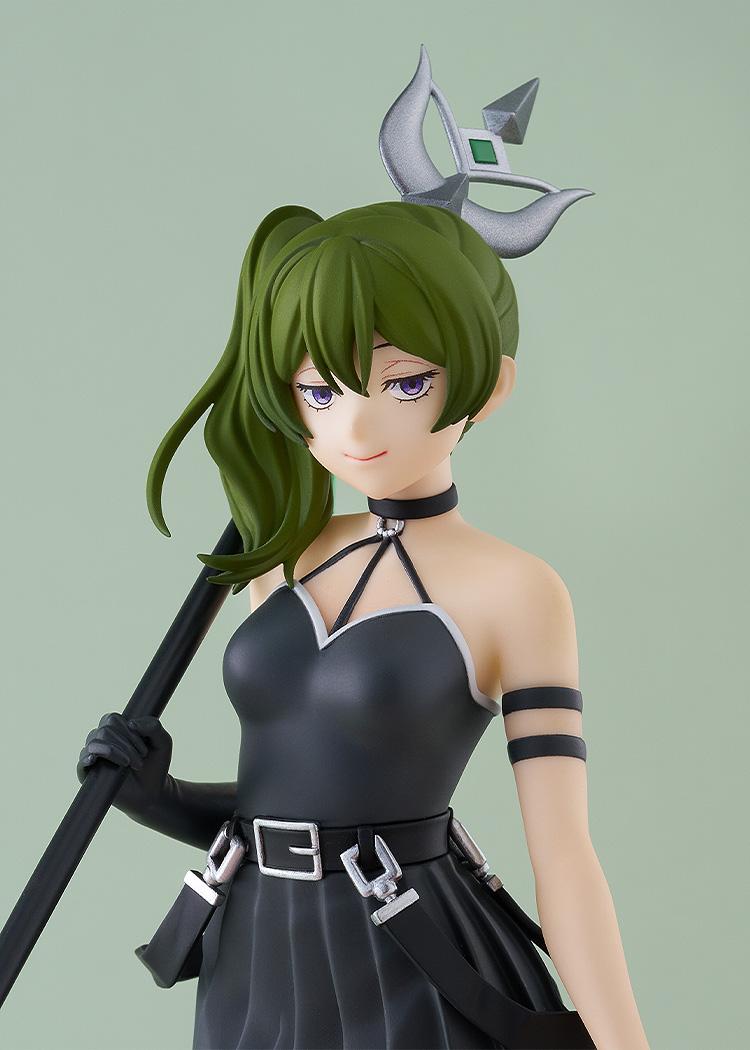 A close-up headshot of the Ubel anime figure, showcasing her smug expression, green side-ponytail, and black choker.
