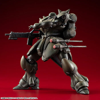 Fully assembled and painted MegaHouse VAKIT Geara Doga Normal Type model kit in a dynamic side-profile action pose on a dark red background.