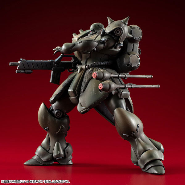 Fully assembled and painted MegaHouse VAKIT Geara Doga Normal Type model kit in a dynamic side-profile action pose on a dark red background.