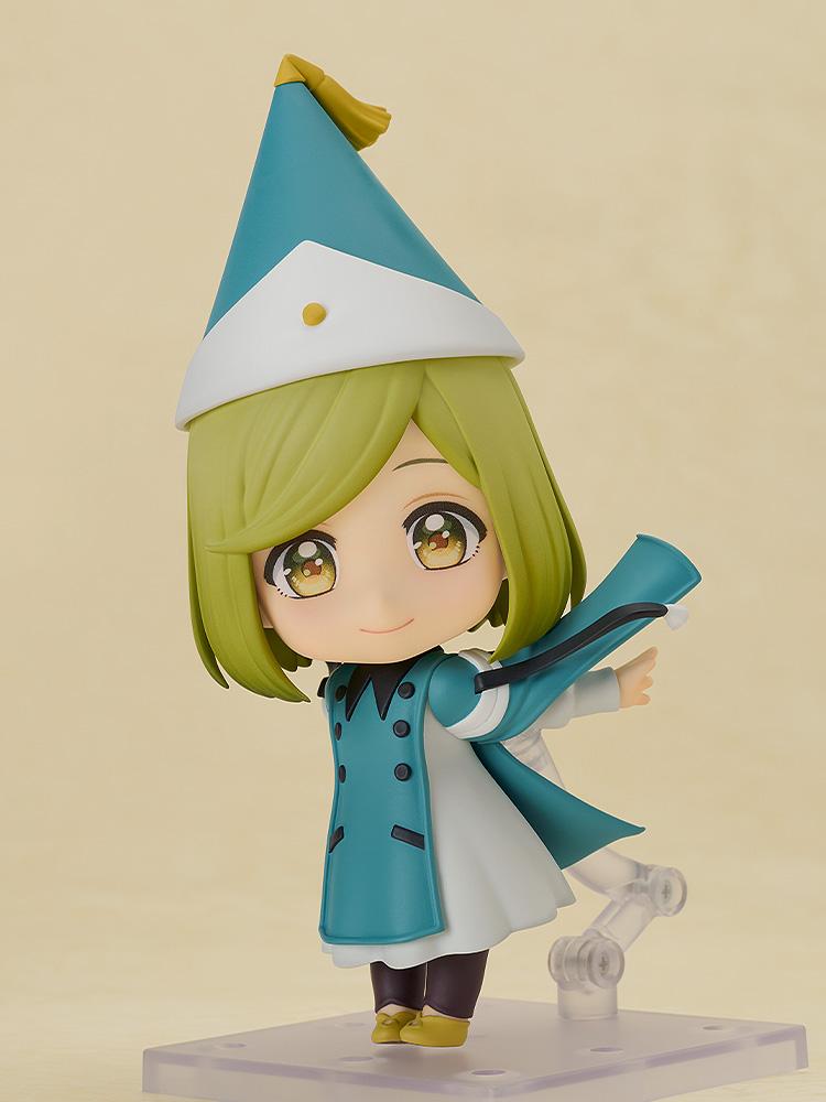 Dynamic action pose of the Coco chibi figure tilted sideways on her articulated display arm, recreating a magical flying movement with her teal cape flowing out.