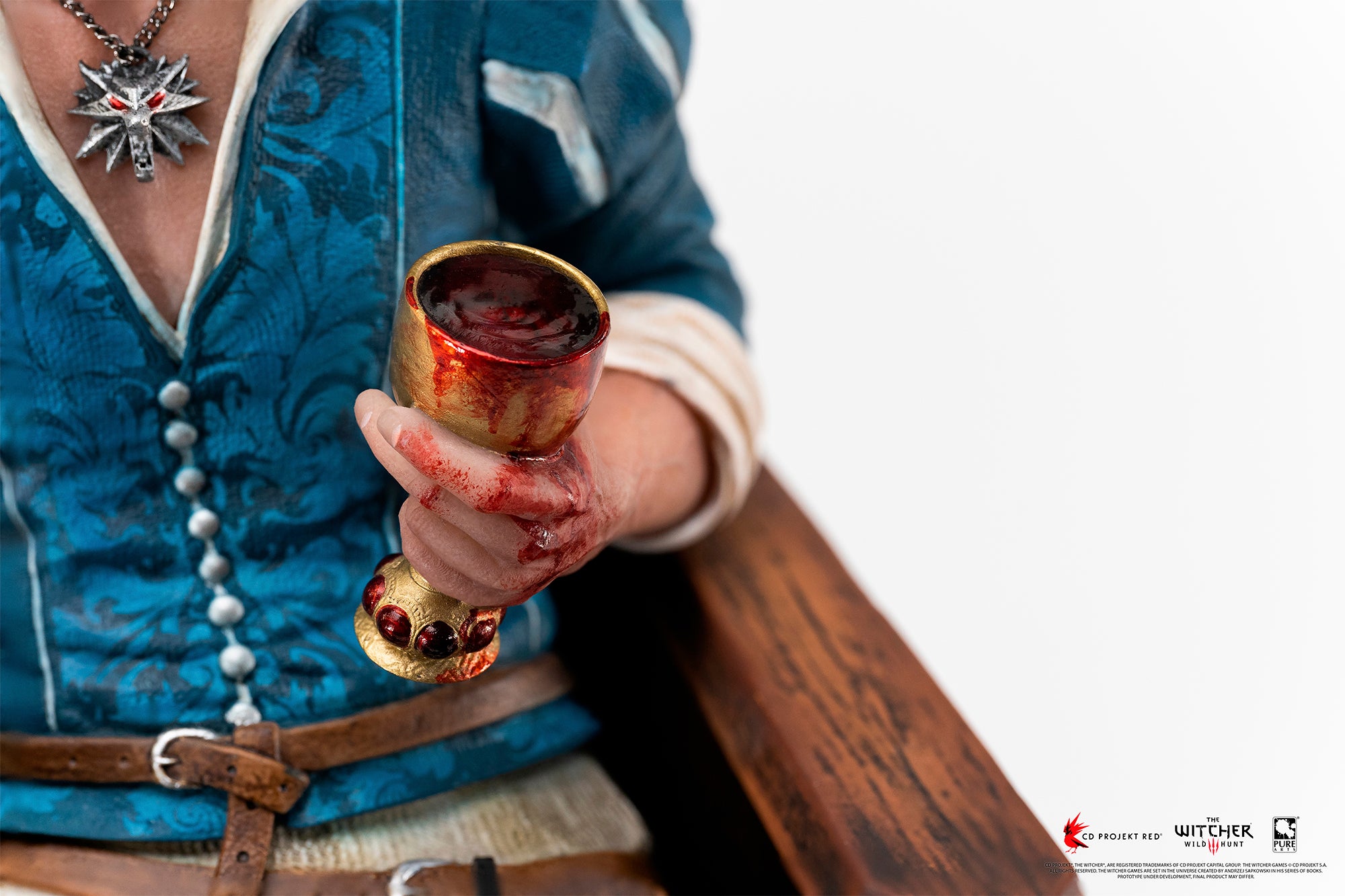 Macro detail of Geralt's hand holding a bloodied golden chalice alongside his Wolf School medallion necklace.