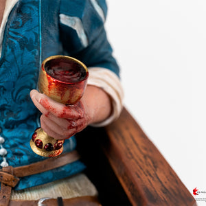 Macro detail of Geralt's hand holding a bloodied golden chalice alongside his Wolf School medallion necklace.