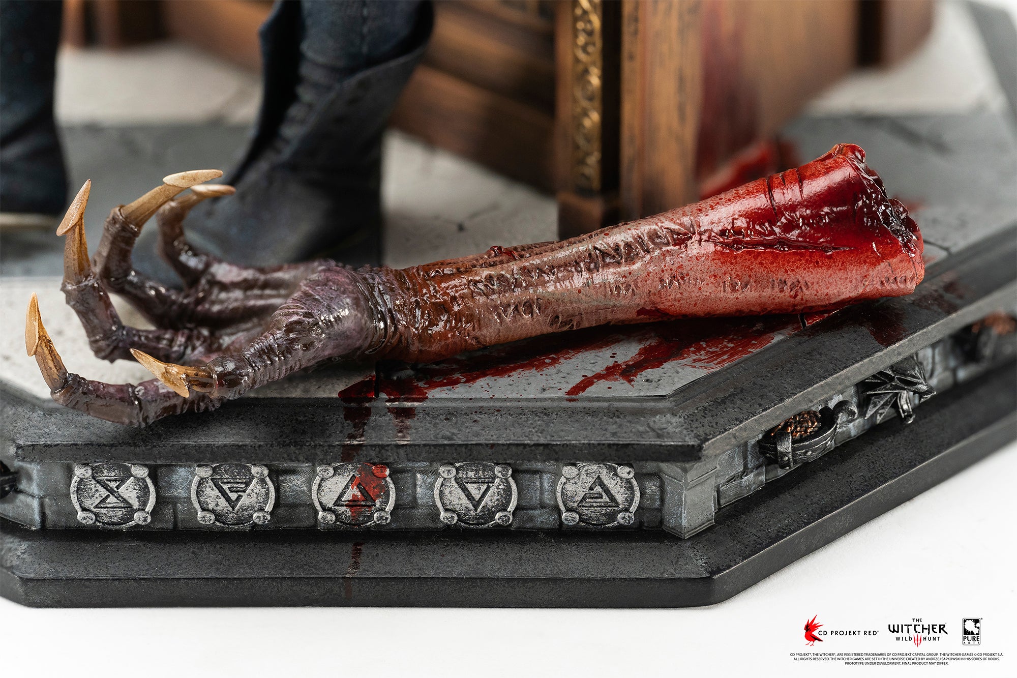 Close-up of the severed arm of High Vampire Dettlaff lying on the stone tiled base etched with Witcher sign symbols.
