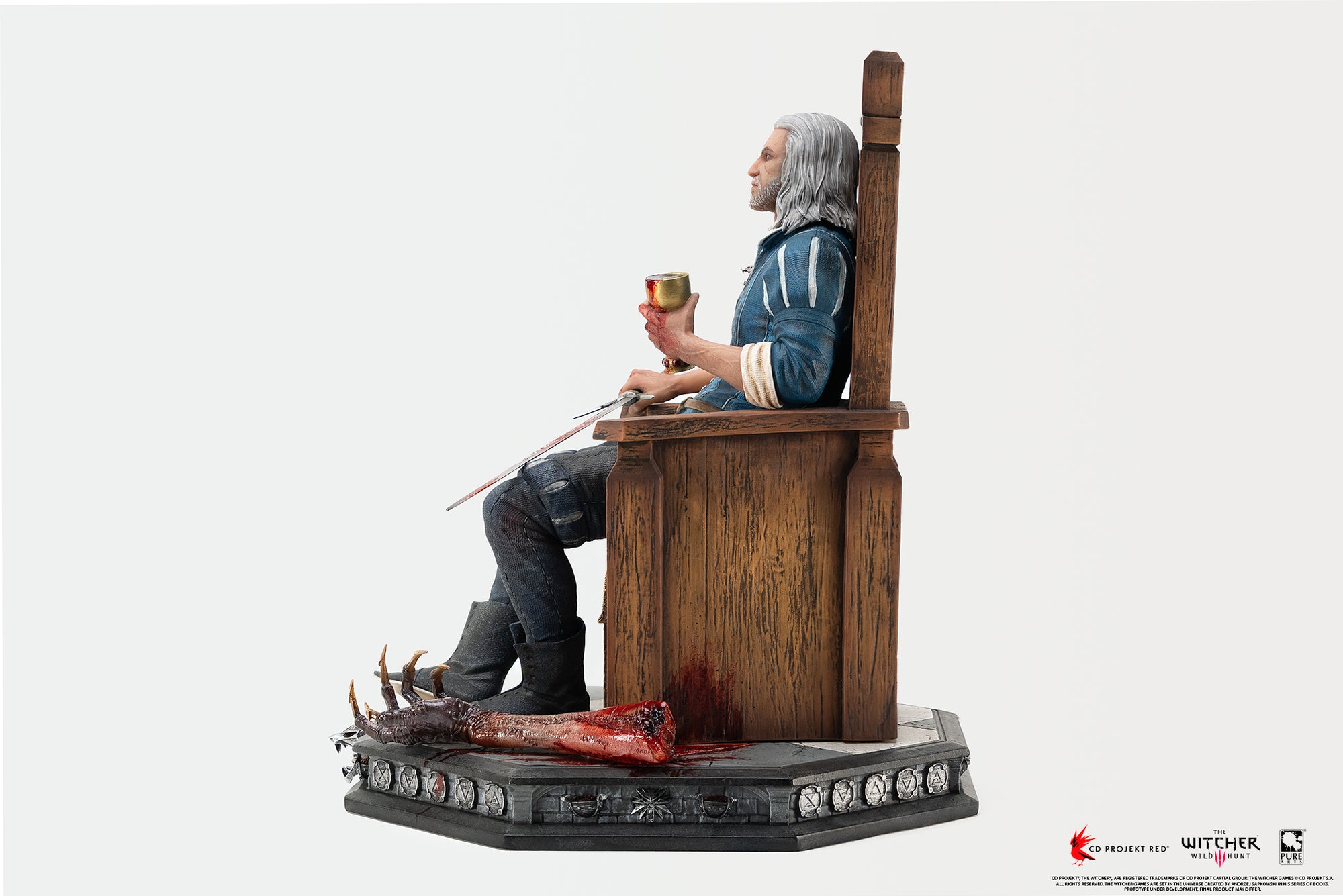 Direct left side view of the 1/6 scale Geralt of Rivia statue seated on his wooden throne, showcasing his posture, chalice, and Dettlaff's severed arm on the base.