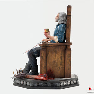 Direct left side view of the 1/6 scale Geralt of Rivia statue seated on his wooden throne, showcasing his posture, chalice, and Dettlaff's severed arm on the base.