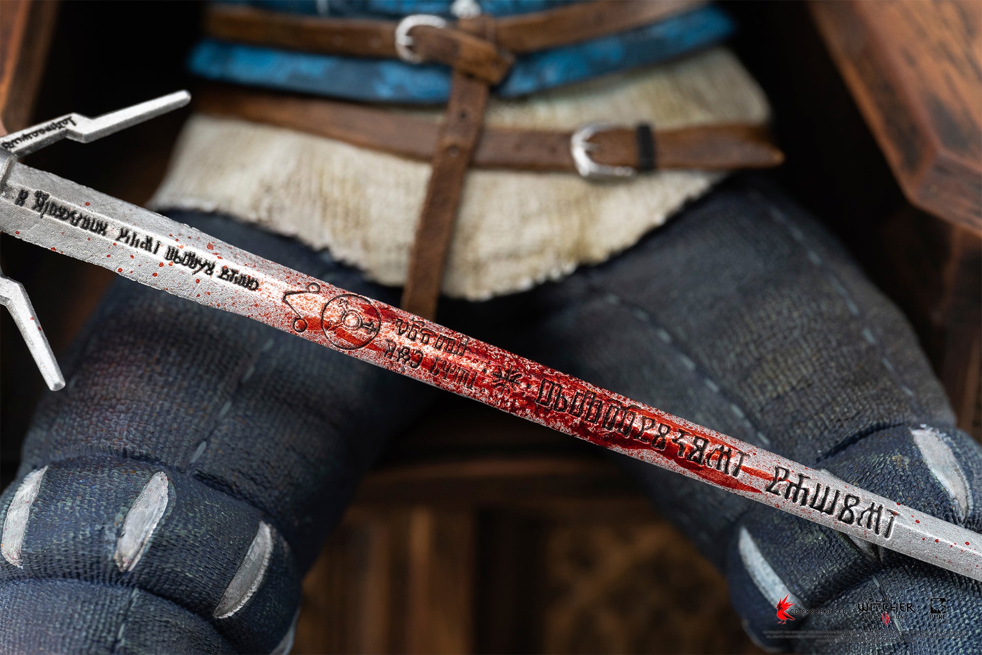 Close-up shot of the blood-stained silver blade detailing carved Witcher runes on Geralt's sword.